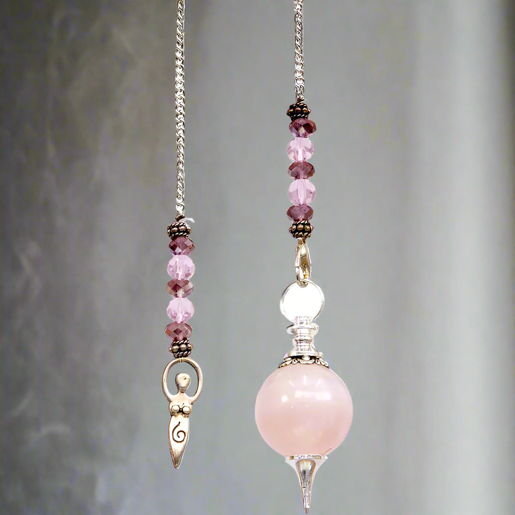 A silver-colored beaded pendulum with a rose quartz sphere and intricate details, handcrafted in India.