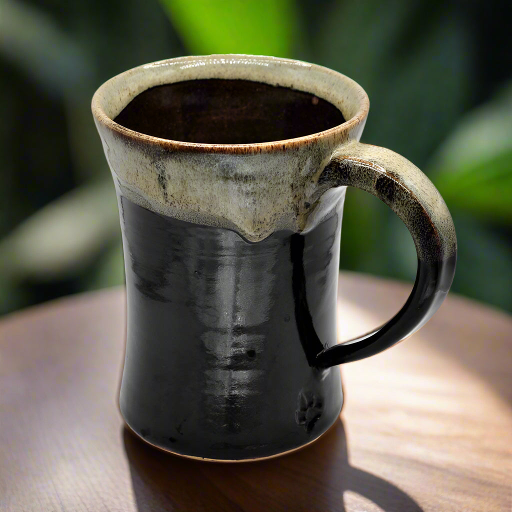 A tall 16oz handmade ceramic mug with a dark brown body and a light brown rim.