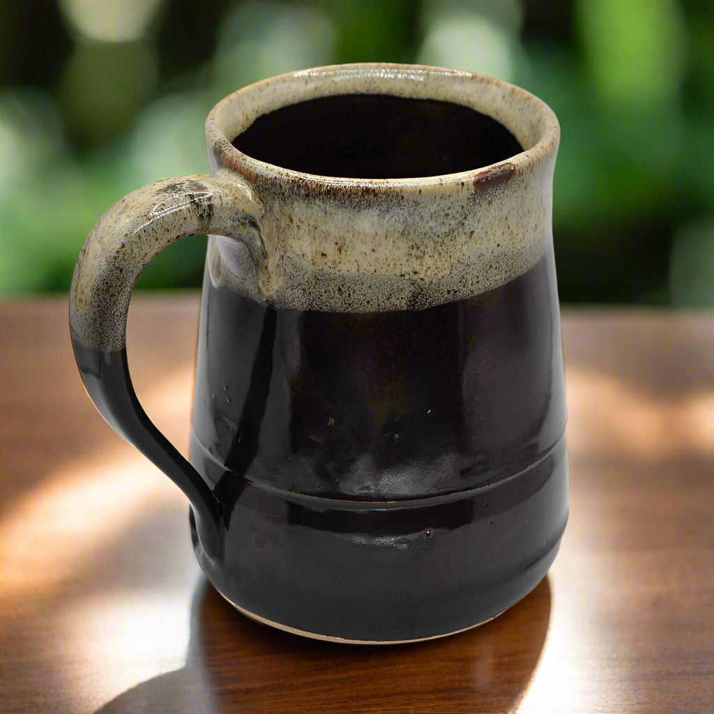 A 16oz ceramic mug with a two-tone color design, darker color with a lighter band around the top edge.